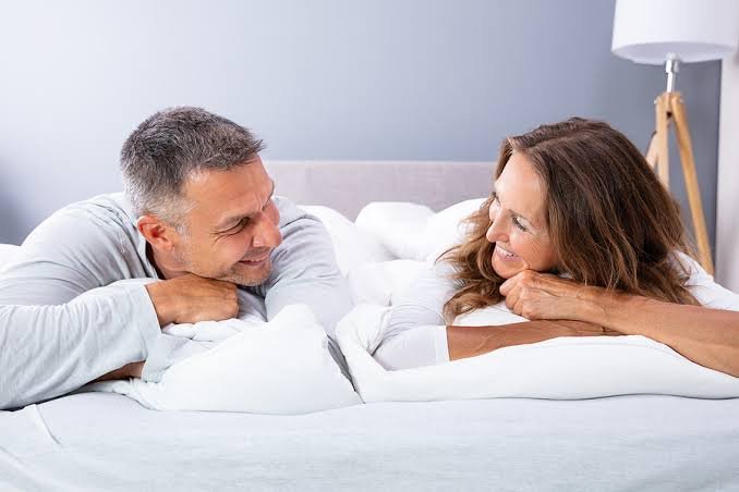 Couple smiling together in a calm bedroom setting